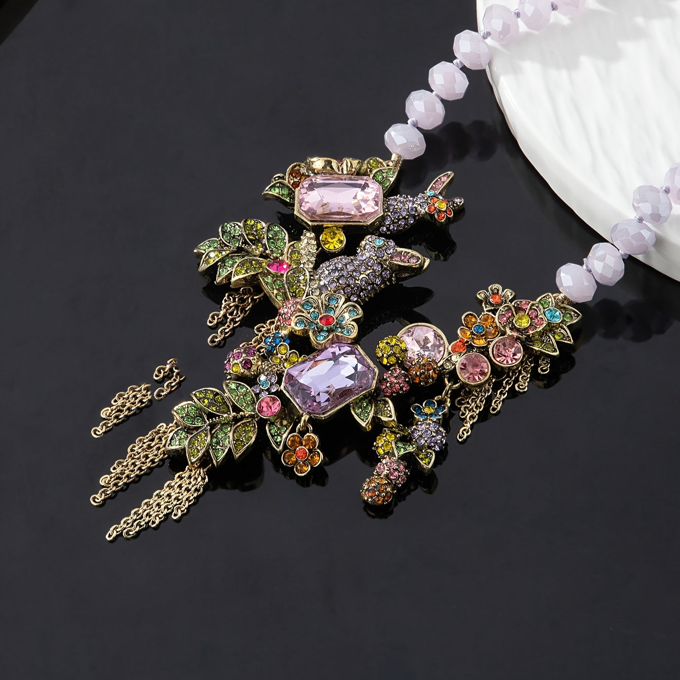 Necklace featuring an ornate vintage-style rabbit pendant with rhinestone tassels, glass crystals, and leaf accents.