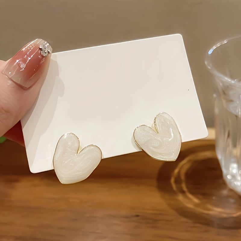 White enamel heart-shaped stud earrings with 925 sterling silver post for everyday and special occasions.