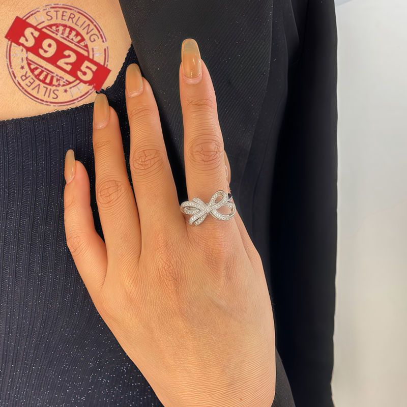 Chic 925 Sterling Silver Ribbon Bow Tie Ring featuring Natural Zirconia, perfect for July Birthdays. This Tribal & Cute style ring is 925 Silver Plated, Tarnish-Resistant, and adorned with Heart-Themed details. Ideal for Daily Wear or Wedding occasions