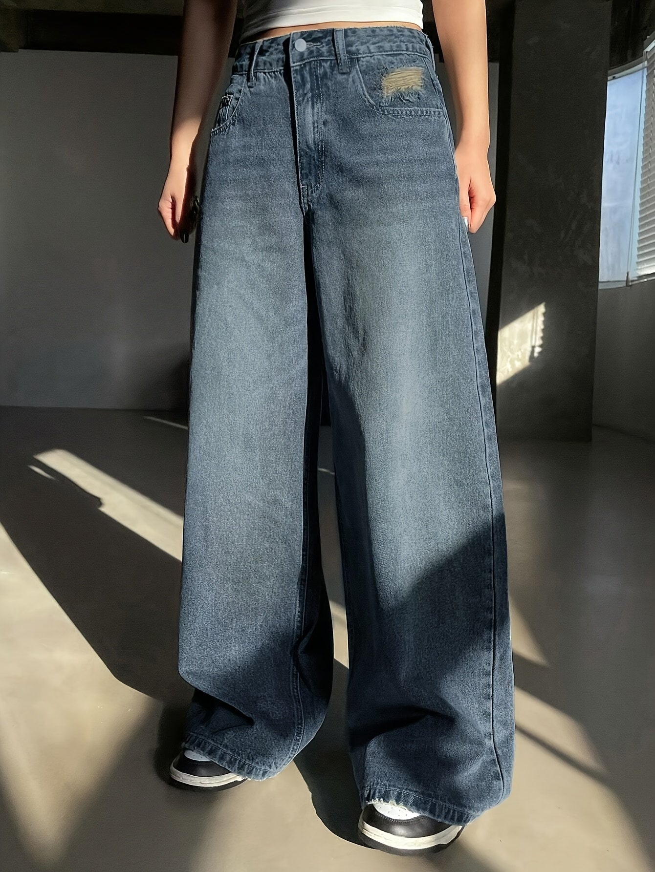 Vintage washed blue wide-leg jeans for women with a loose fit, high-rise, zipper and button closure, made from stretch denim for an elegant retro style. Perfect for casual wear with durable