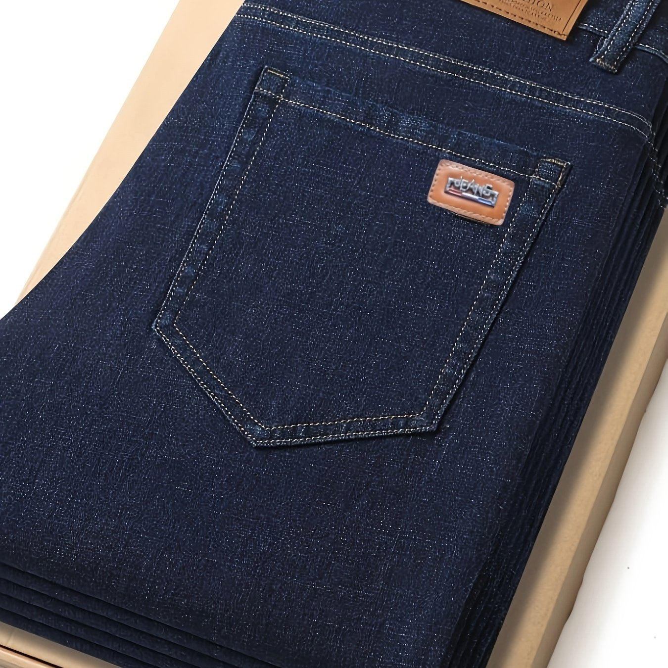 Men's dark blue jeans with patch, straight leg fit, ribbed cuffs, and durable cotton blend denim. Machine washable, comfortable, and smooth fabric.