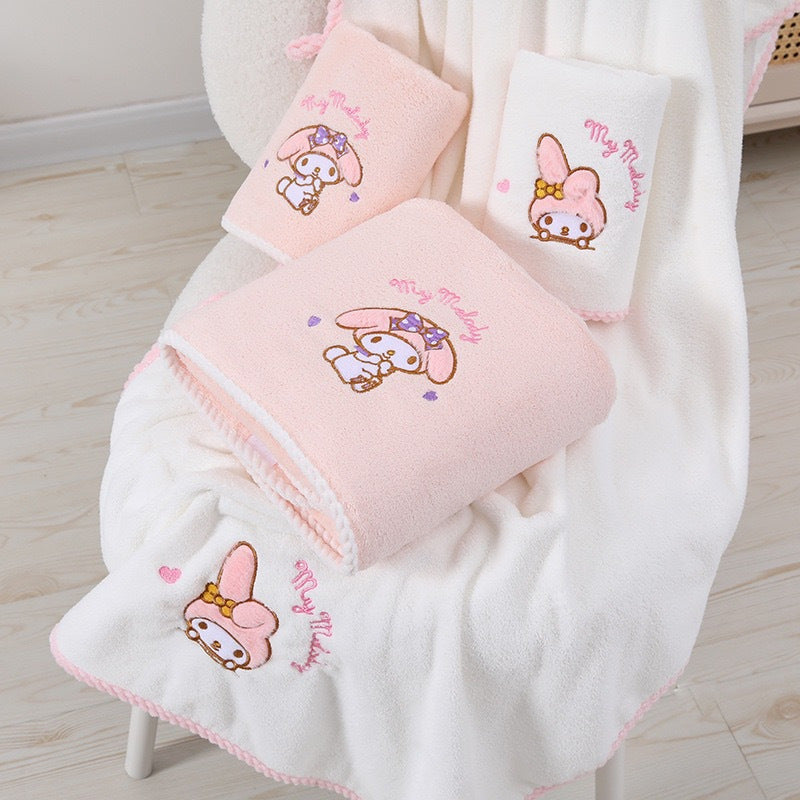 Contemporary cartoon-themed Hello Kitty and Friends plush bath towels in knit fabric made from a 40% cotton, 60% acrylic blend. Featuring a checkered pattern, low lint, 280gsm, and oblong shape, ideal for wash cloths.