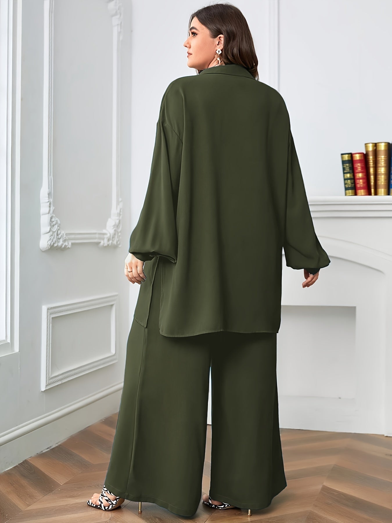 Black polyester blend pants with split details and a relaxed blouse comprise an elegant oversized V-neck two-piece set.