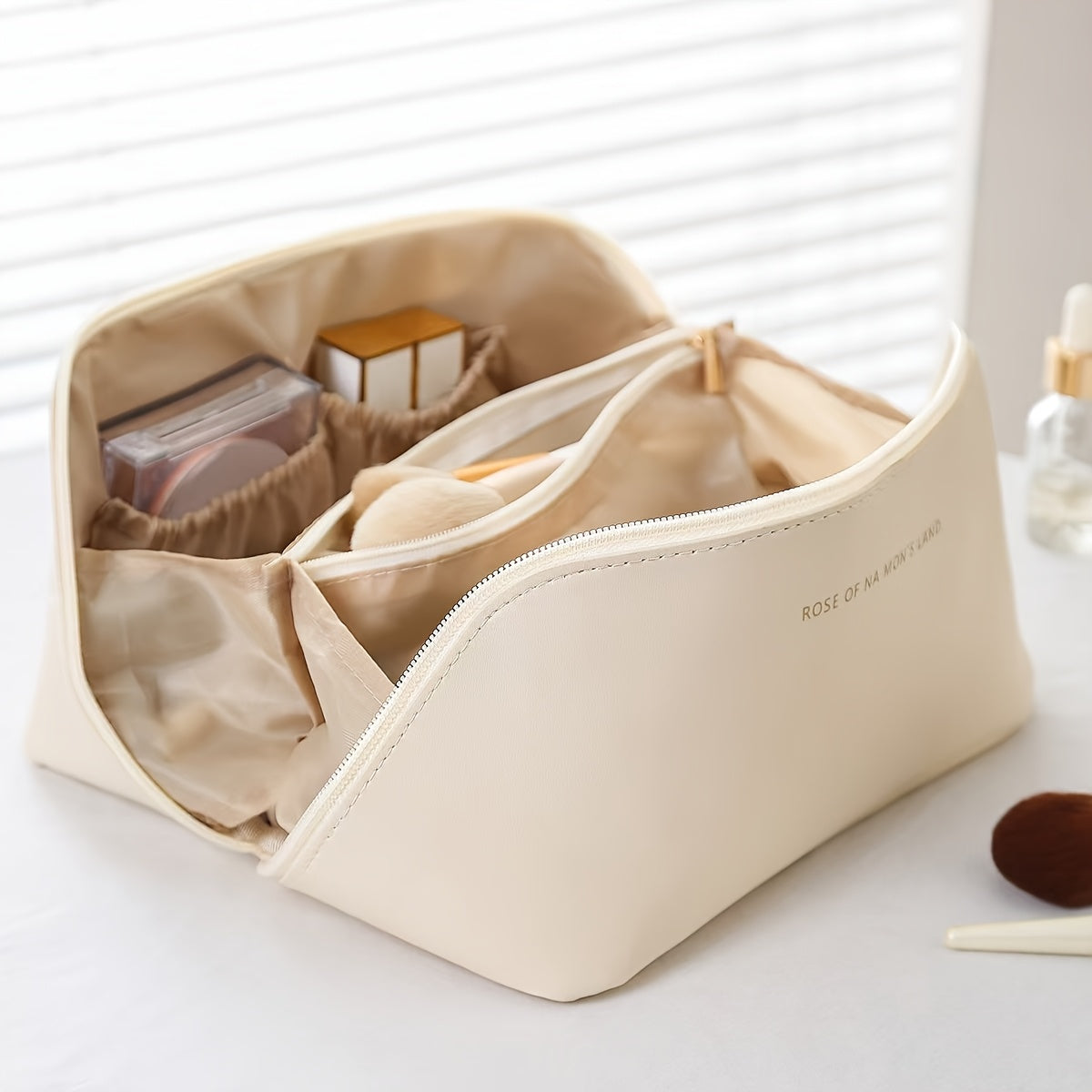 Large travel makeup bag with waterproof, portable design and divider for organizing makeup.