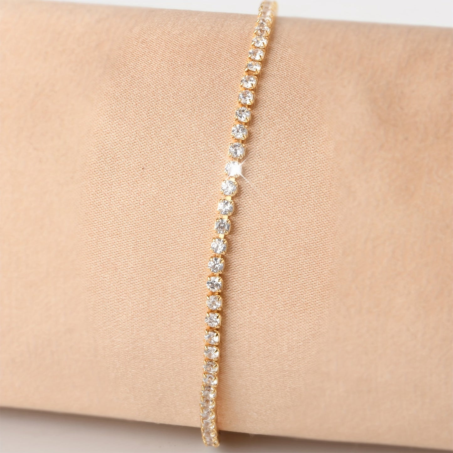 Golden plated copper hand jewelry accessory, featuring inlaid shiny zirconia stones in a tennis bracelet design. Perfect gift for Mother's Day.