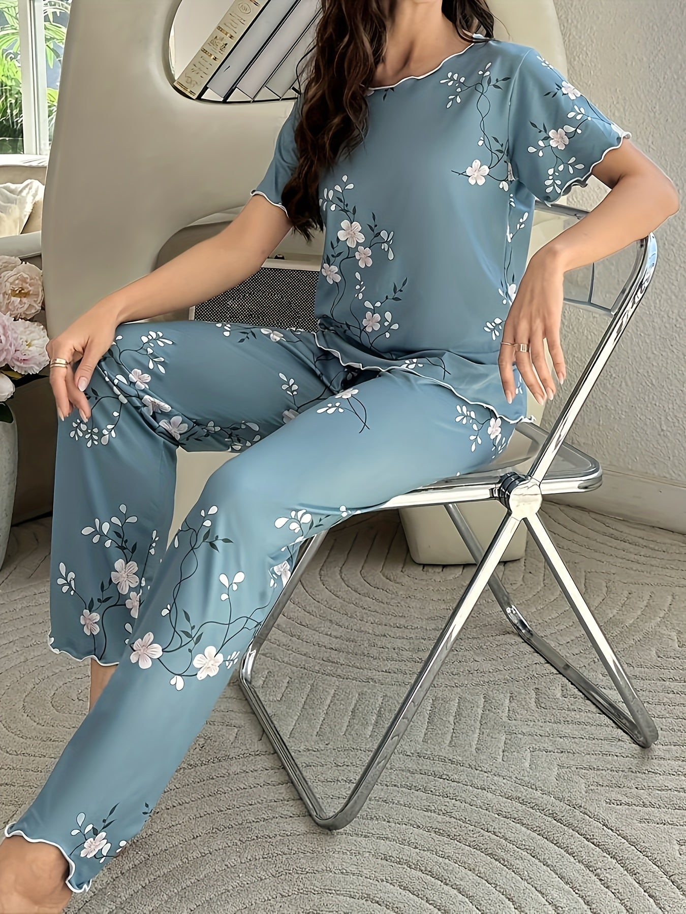 Women's sleepwear set with floral print, frill trim, short sleeve top, and elastic pants.