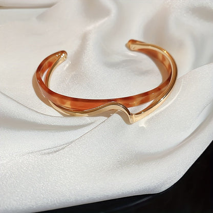 Wave-shaped cuff bangle with faux pearl inlay, featuring a minimalist style in 18K gold plating, ideal for women's jewelry collection