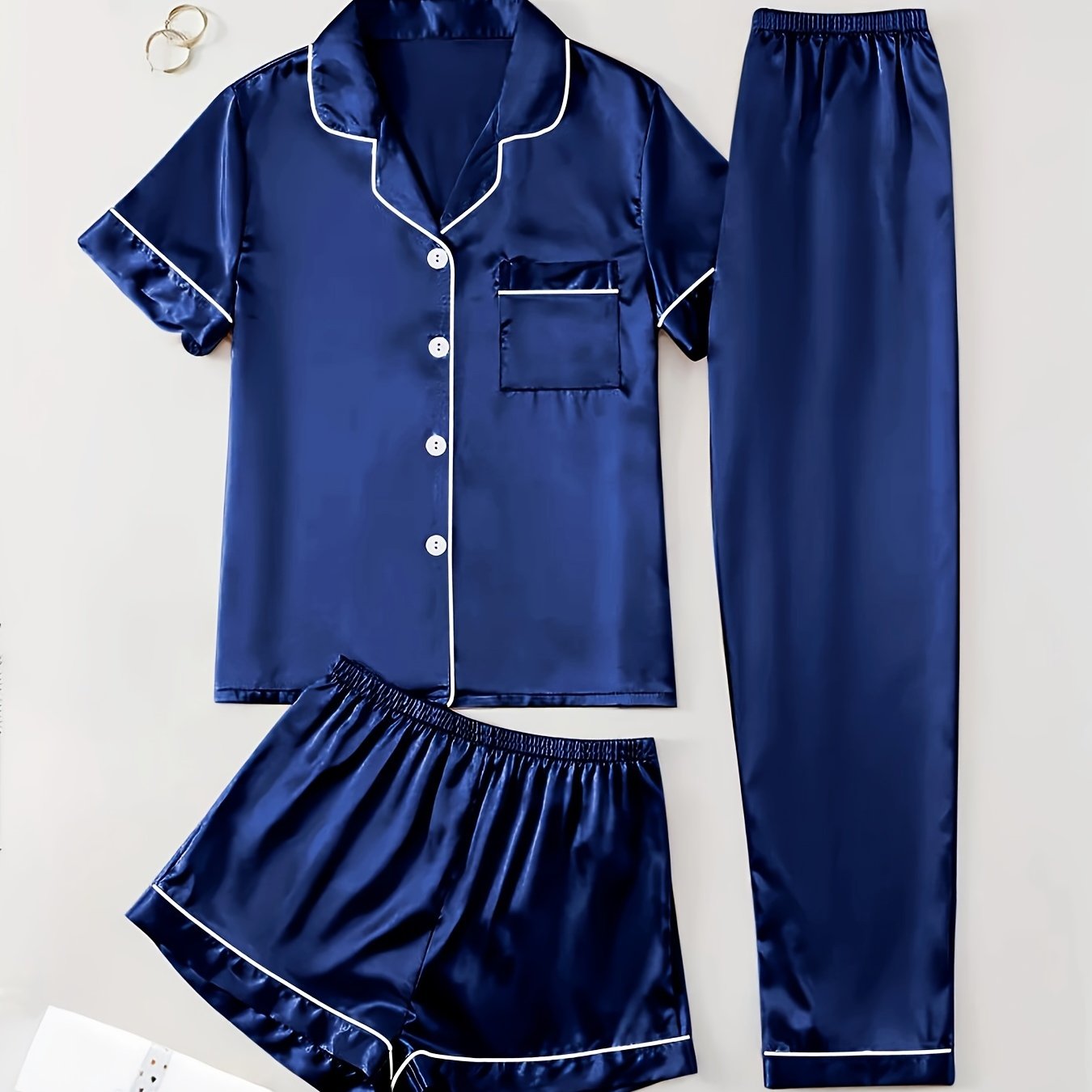 3-piece summer satin pajama set for women featuring collared shirt, long pants, and shorts. Made of 95% polyester and 5% elastane. Available in sizes S-XL.