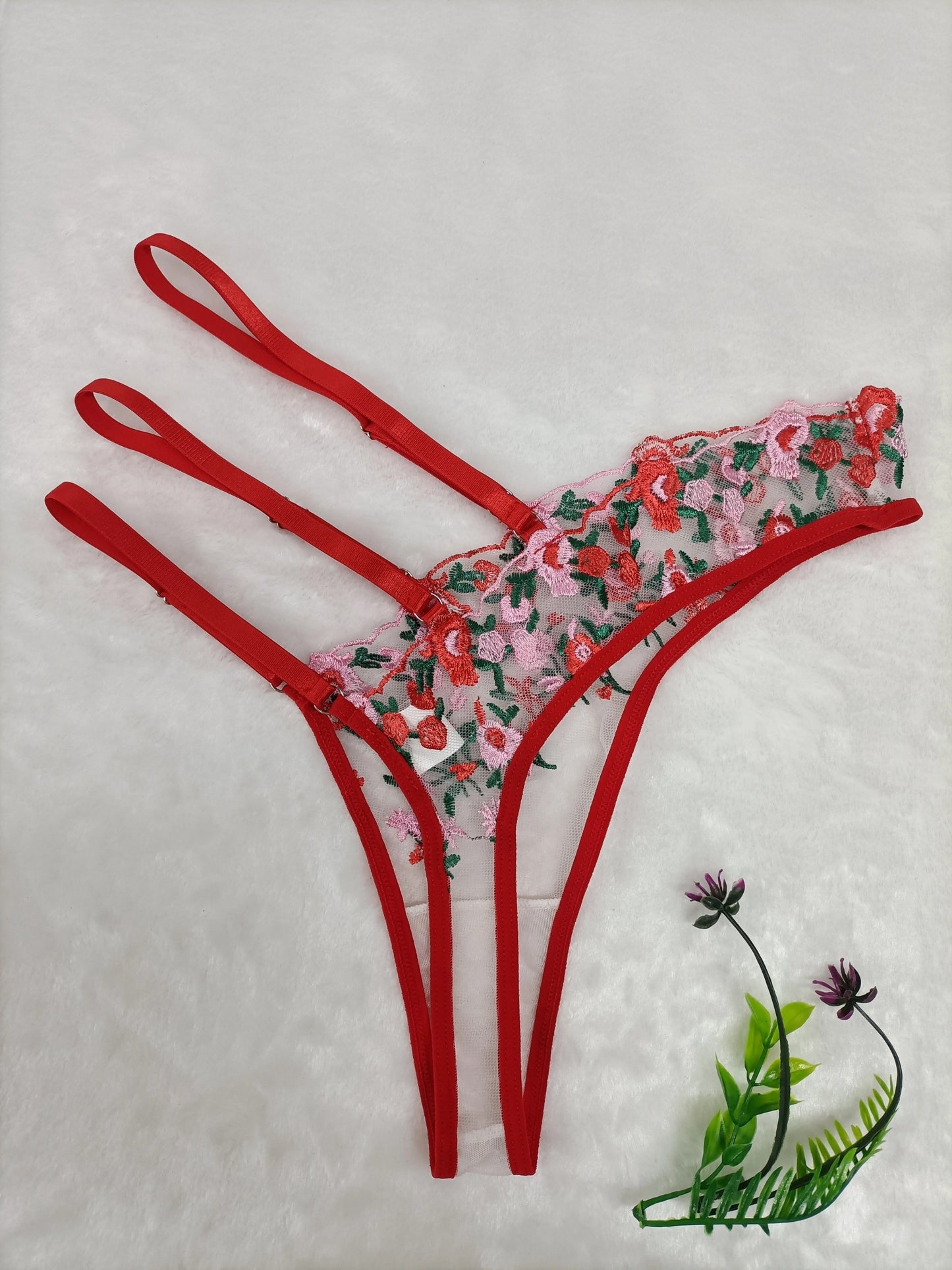 Seductive lace thong panties with sheer mesh and embroidered details, made of 95% polyester and 5% elastane knit fabric for adult intimate wear.