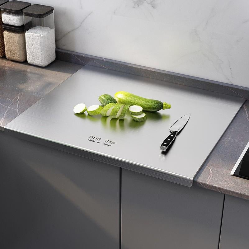 A durable stainless steel cutting board that is extra-large, double-sided, and thick for kitchen use, made of food-safe material.