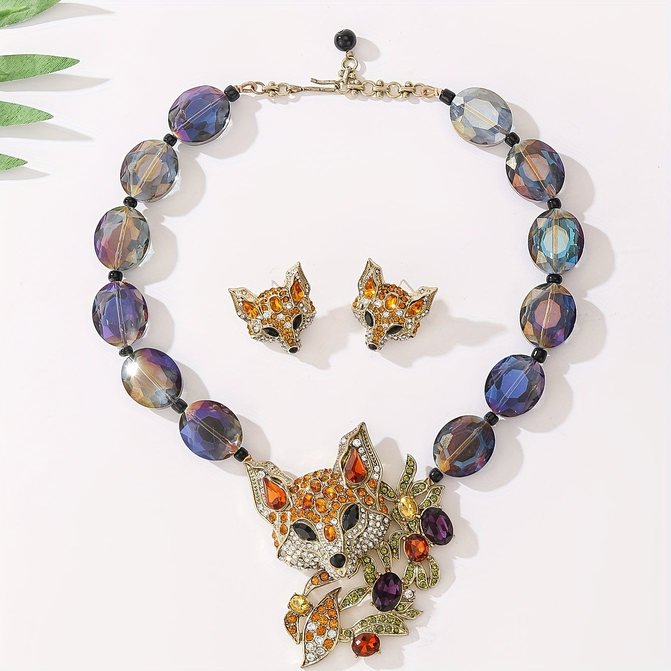 This luxury and exquisitely designed jewelry set features a pendant necklace and earrings adorned with inlaid water diamonds, fox leaves, and colorful acrylic beads. The set is elegant and fashionable, making it the perfect gift for women. It is ideal