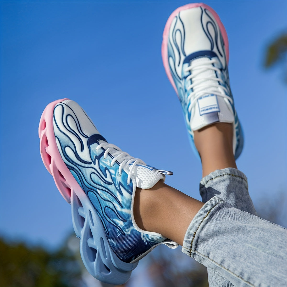 Versatile all-season lightweight running shoes in blue and pink ombre with breathable fabric and lace-up closure.