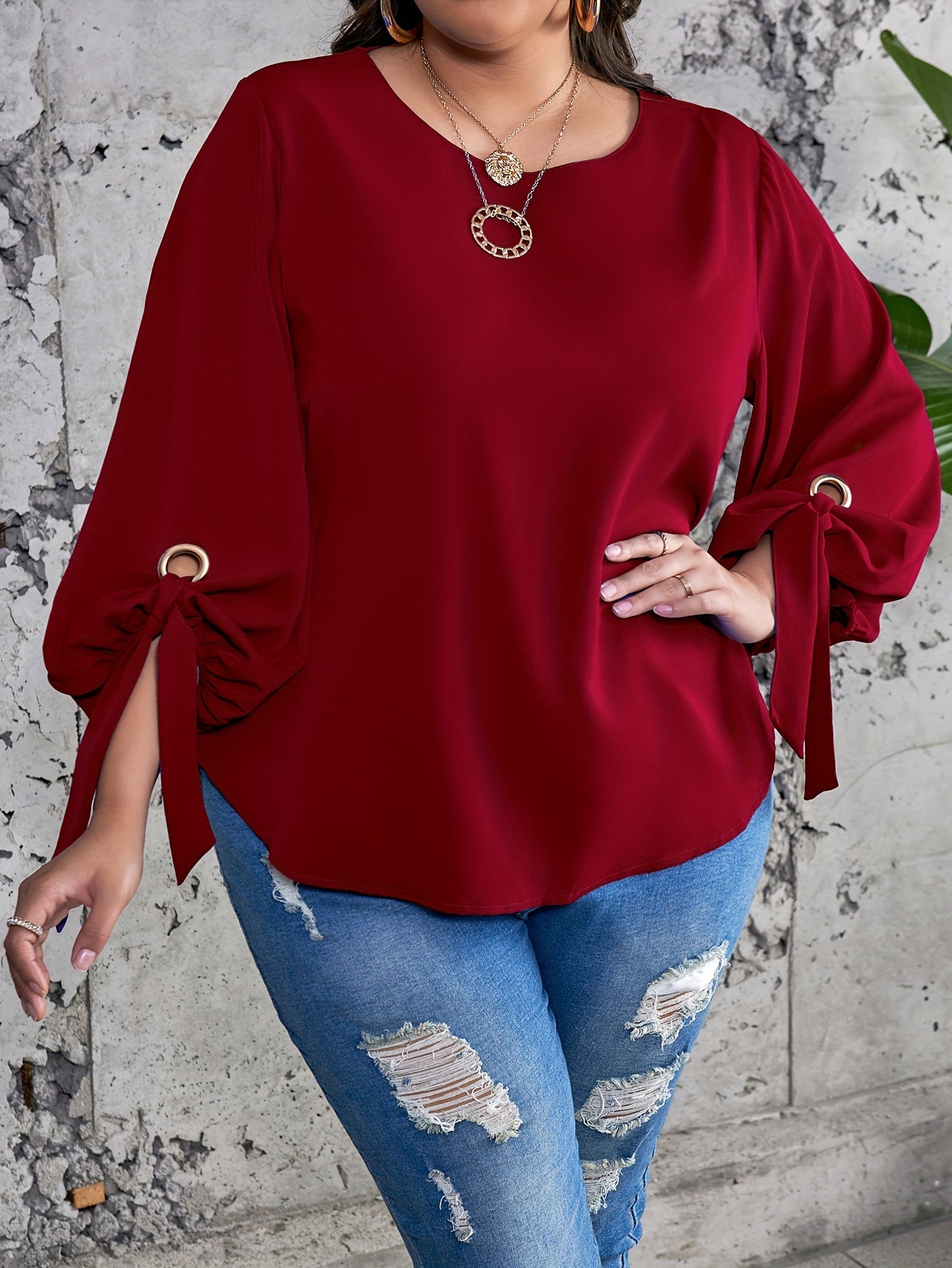 Plus size women's casual top with solid colors, lantern sleeves, round neck, round hem, and knot detail.