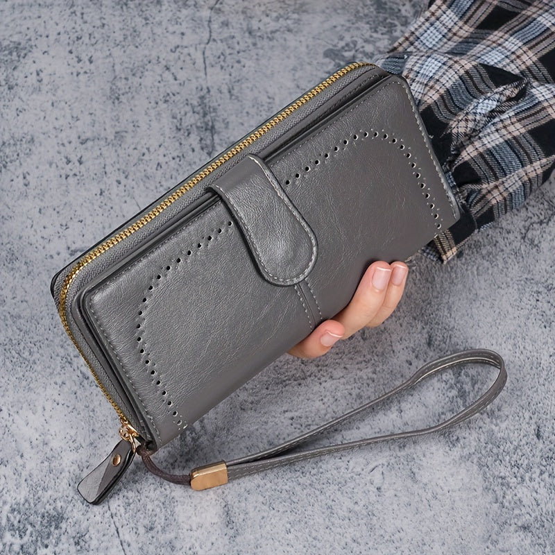 Black faux leather long clutch wallet with wristlet, ID card compartment, button closure, and edge paint. Dry clean only.