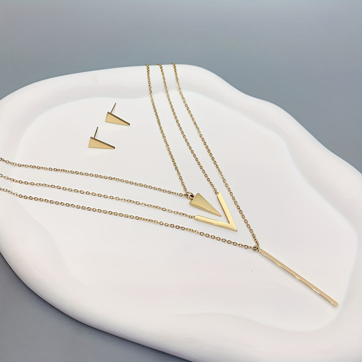 Three pieces of Stainless Steel Long Strip V-shaped Geometric Pendant with a Multi-layer Necklace and Triangle Earrings. Perfect as a Birthday or Holiday Gift, Clothing Decoration, or Party Accessories.