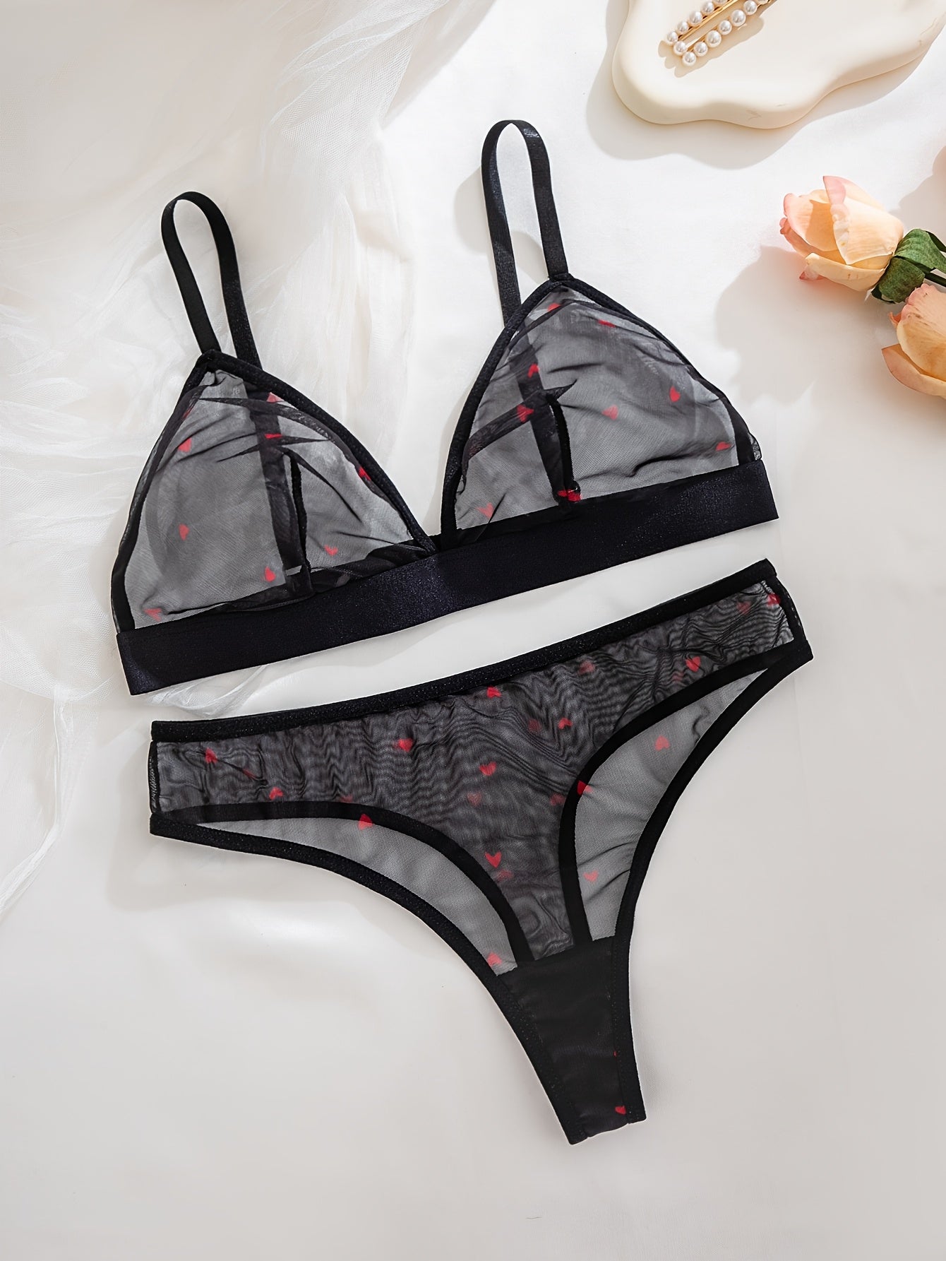 Sexy black sheer mesh lingerie set with red heart pattern, medium support, no underwire, drop waist, made of 90% polyester and 10% elastane.