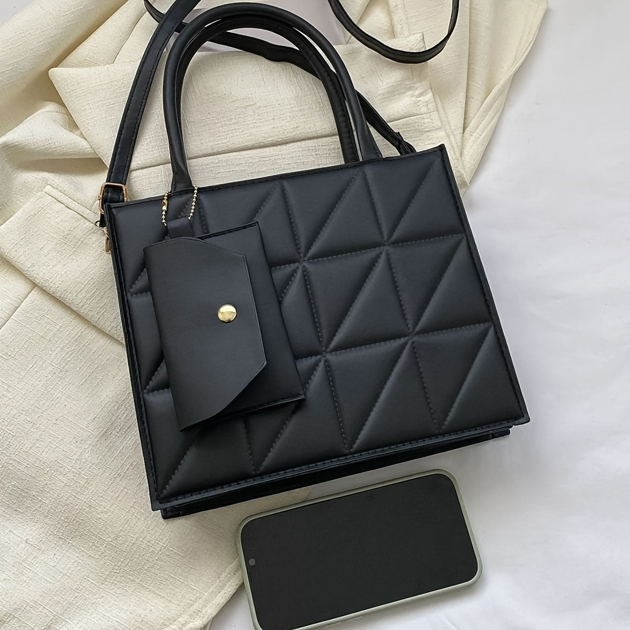 Black quilted synthetic leather tote bag with gold-tone hardware and detachable crossbody strap. Includes matching coin purse. Perfect for work, office, and everyday use. Ideal commuter