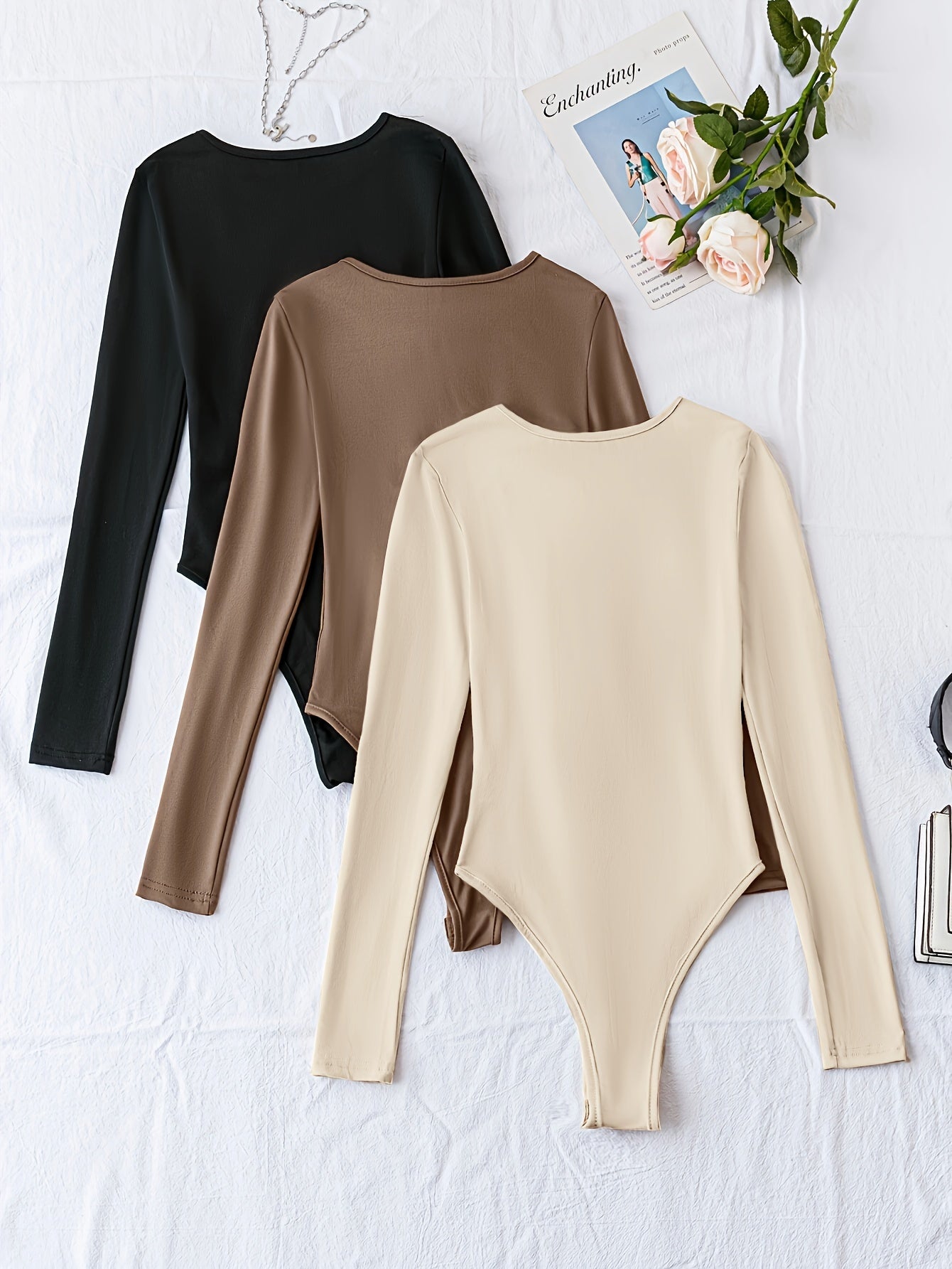 Pack of three solid crew neck long sleeve bodysuits for women. Casual one-piece clothing.