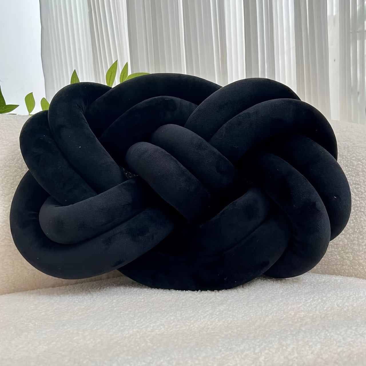 Knotted throw pillow for home decor, suitable for bed or sofa.