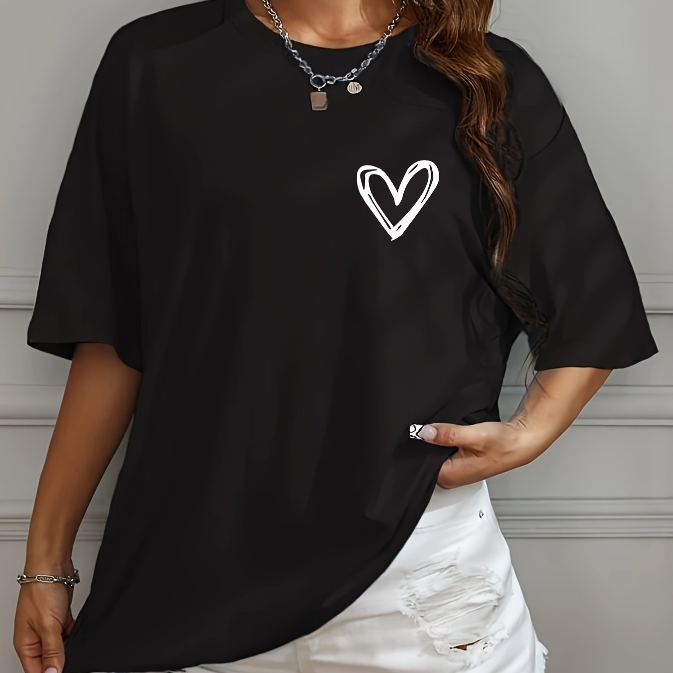 Casual loose-fit drop shoulder t-shirt for women with chic heart print. Made of soft polyester, short sleeve, and round neck. Machine washable and perfect for everyday style.