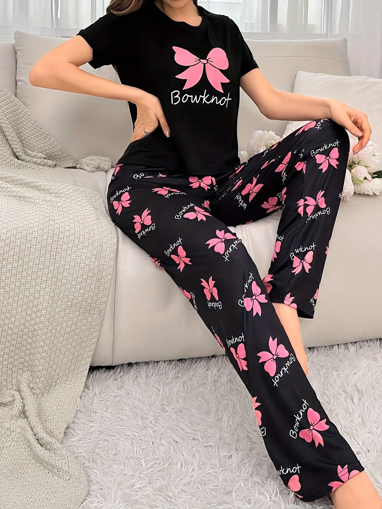 Cozy bowknot pajama set for women with short sleeves and elastic waistband pants. Made from soft, machine washable polyester blend in black with pink butterfly print.