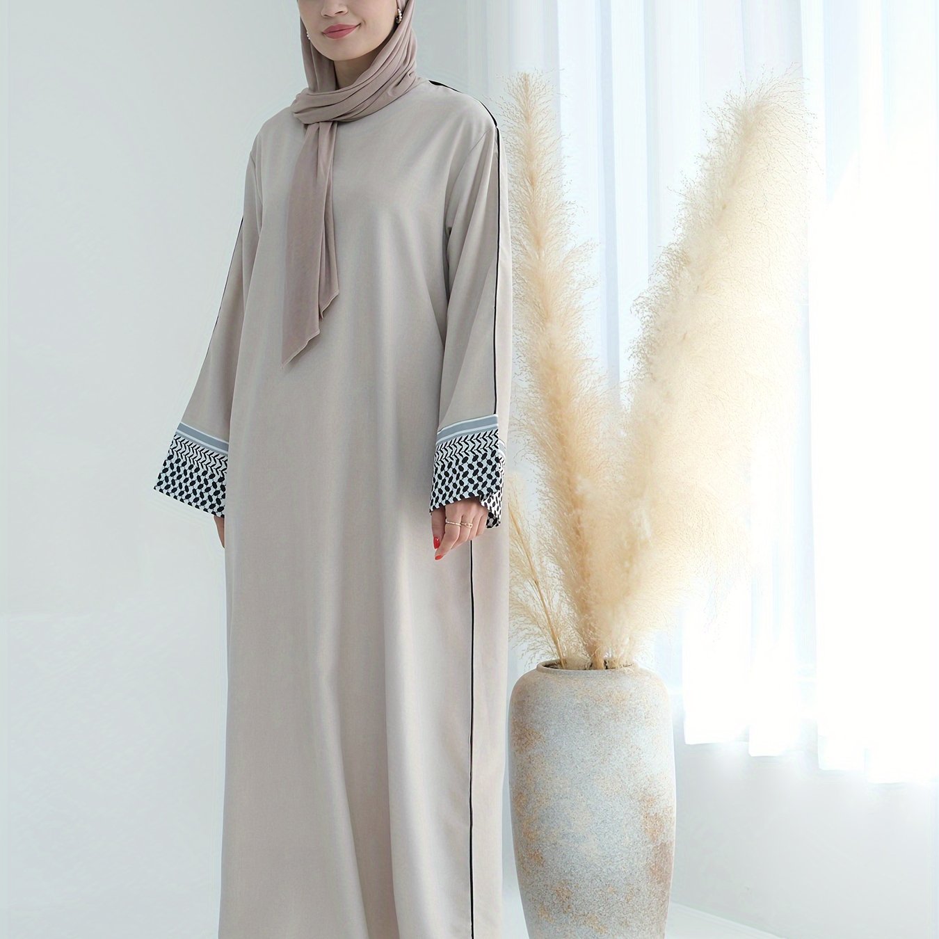 Stylish embroidered zippered abaya dress with long sleeves for Middle Eastern Muslim fashion. Made from polyester knit fabric, part of the spring/fall collection. Features a regular fit and