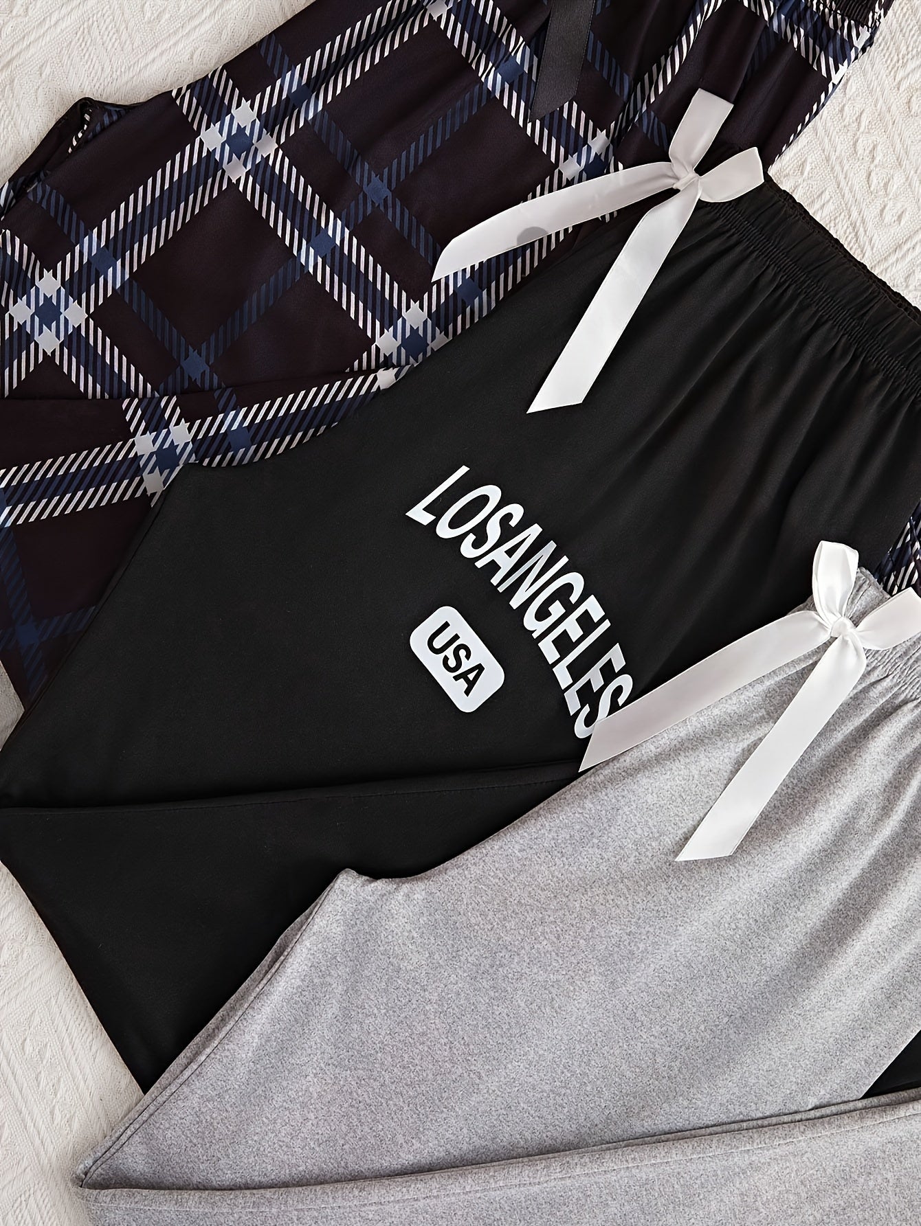 3 Women's lounge pants with plaid and "LOS ANGELES" print. Made of comfy polyester blend with elastic waist and bow detail. Suitable for all-season sleepwear and casual wear.