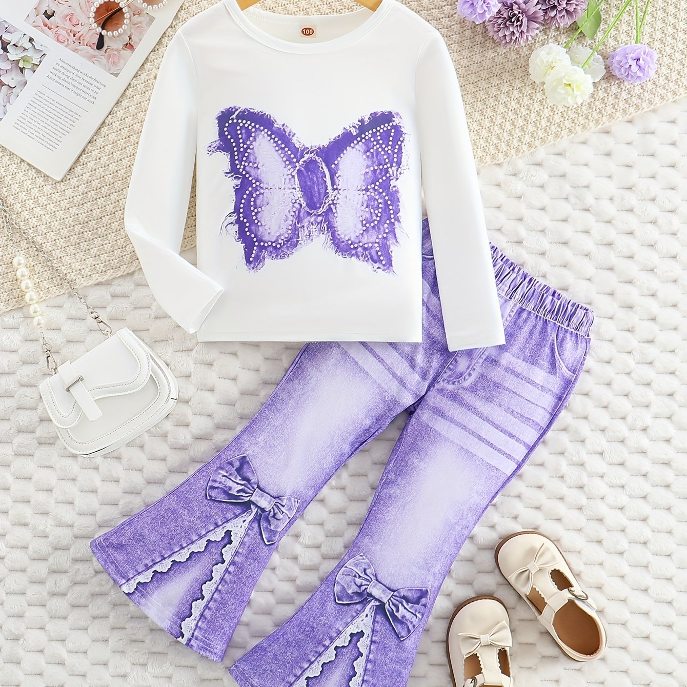 Girls' outfit set includes a long sleeve top with butterfly print and flared faux denim pants with a bow detail. Made of slight stretch knit fabric with an animal pattern, this regular fit