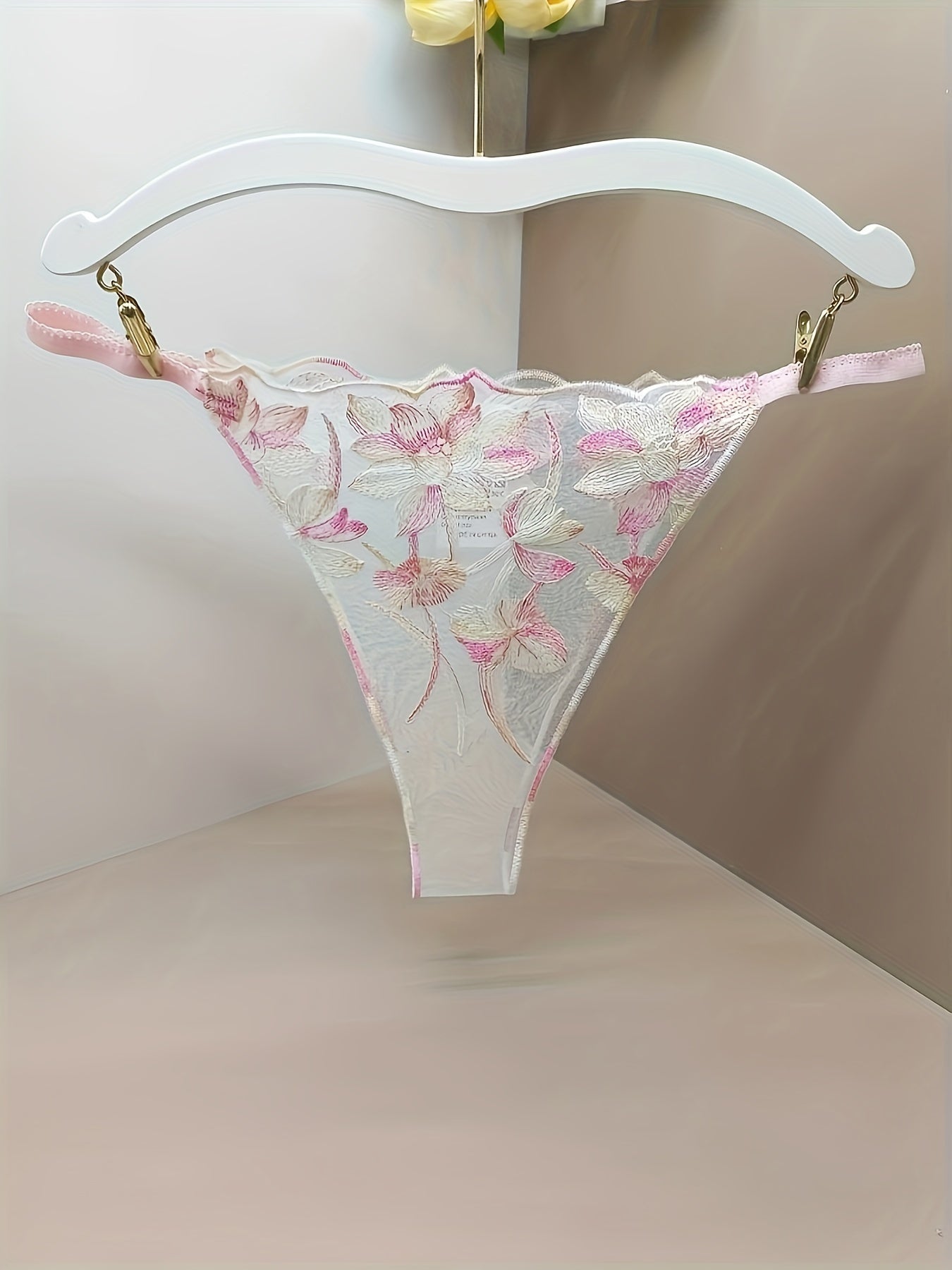 Women's sheer mesh thong panties with embroidered floral design and open crotch, featuring bow detail. Soft and breathable lingerie.