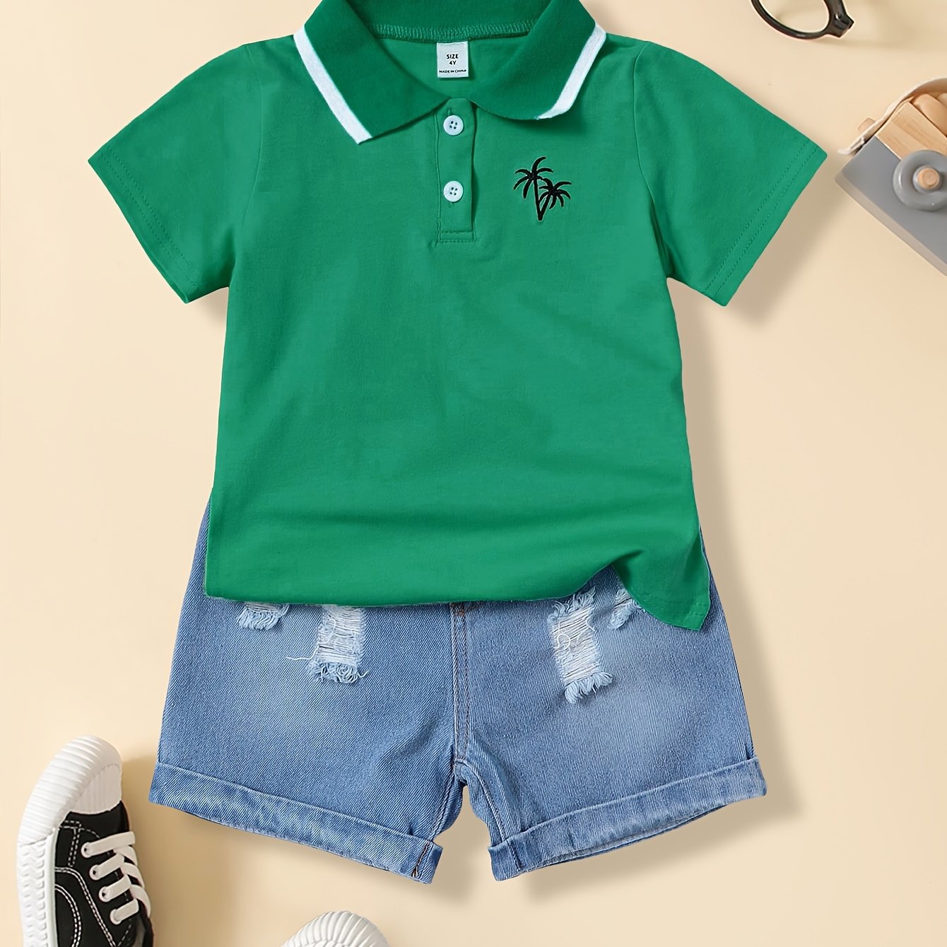 Boys' casual t-shirt with coconut tree design, made of polyester blend with medium stretch. This short sleeve top features a lapel collar and button detail, perfect for weekends. Suitable