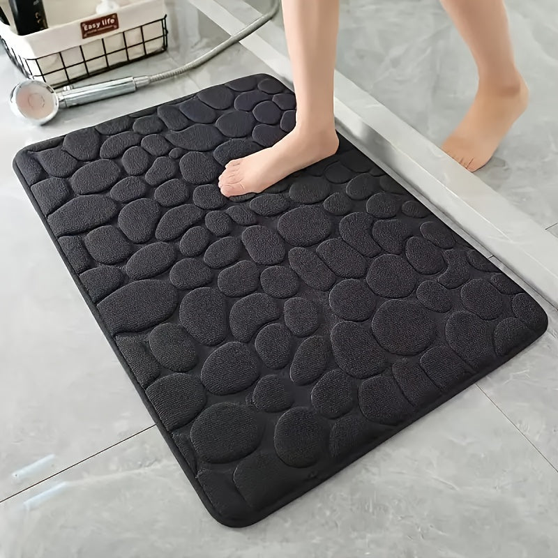 Soft and luxurious memory foam bath mat with a non-slip pebble design. This water-absorbent bathroom rug is machine washable and made of flat woven polyester with PVC backing. Featuring a low pile and solid pattern, it has non-slip capabilities for added