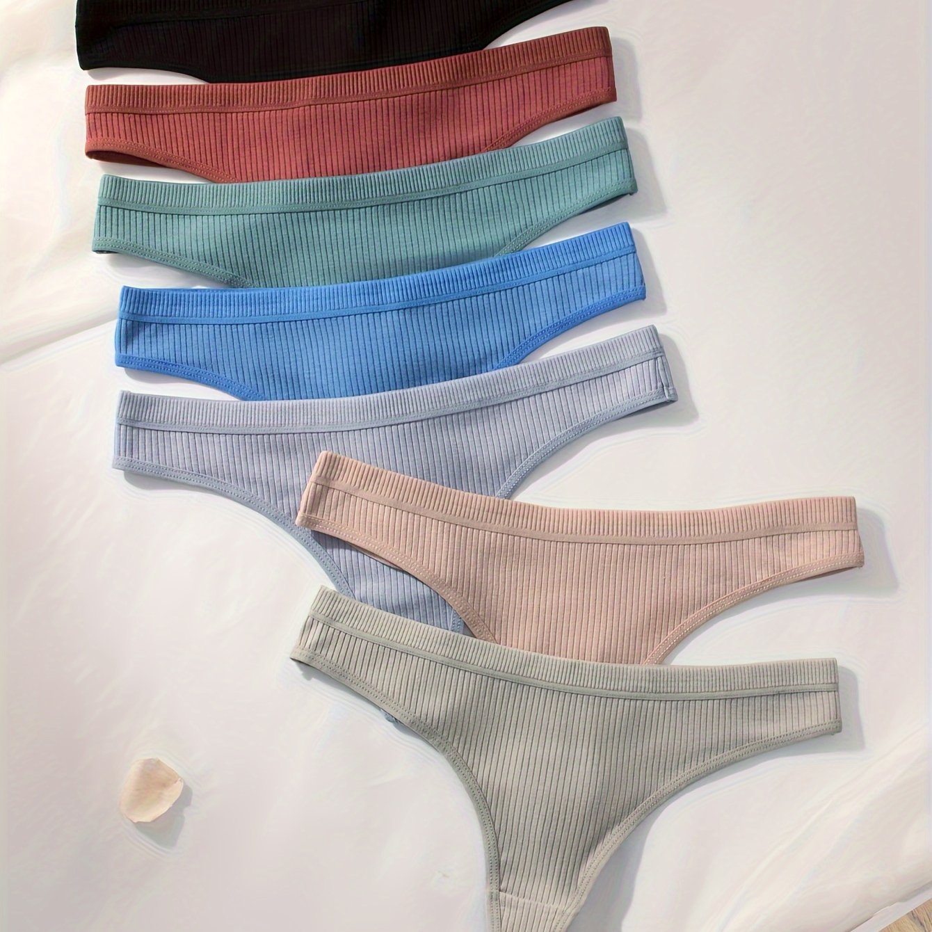 7-pack of women's ribbed thongs in solid colors, made of soft, stretchy polyester blend. Non-see-through, great for casual wear.