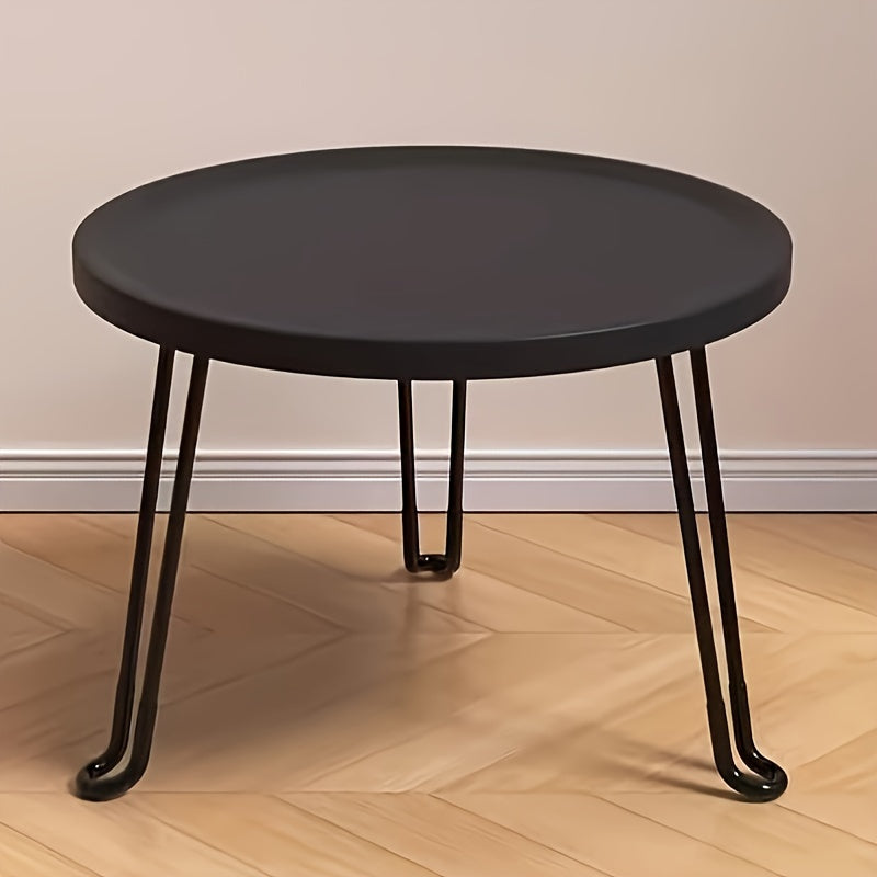 Compact and modern, this small round folding coffee table features a tray surface supported by three legs. Ideal for use as a bedside table in bedrooms and living rooms, this piece is perfect for compact spaces.