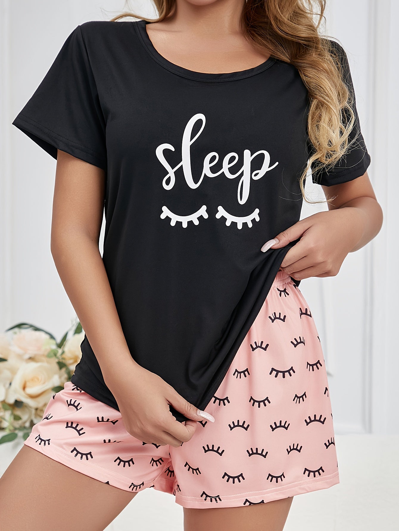 Women's loungewear set featuring eyelash and letter print, including a short-sleeve top and elastic shorts.