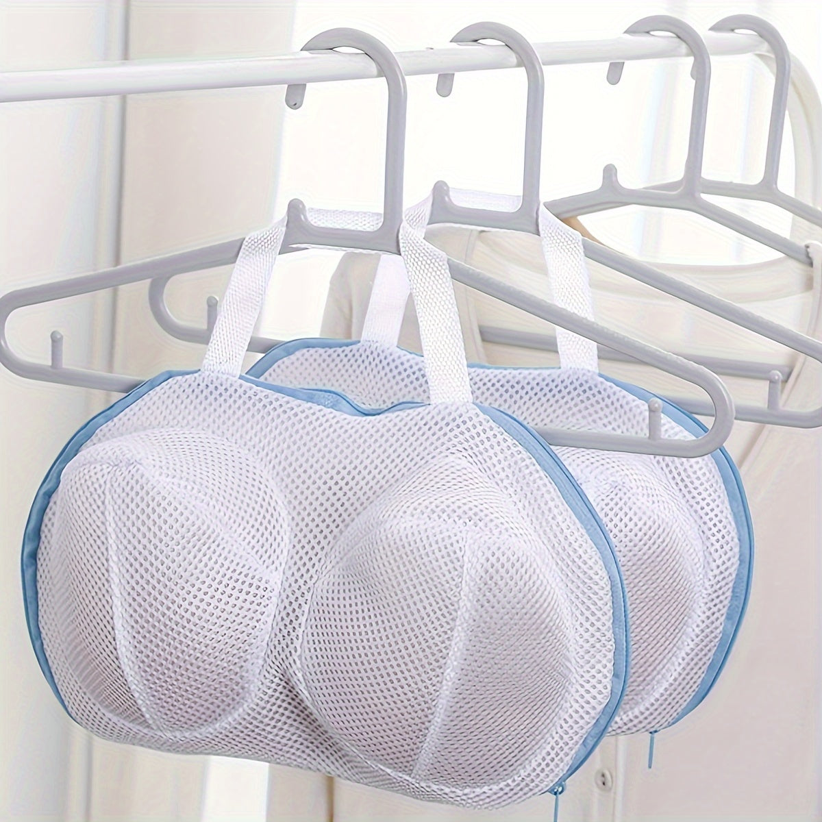 Mesh laundry bag with zipper closure for delicate clothing, durable and round-shaped, made of woven material.