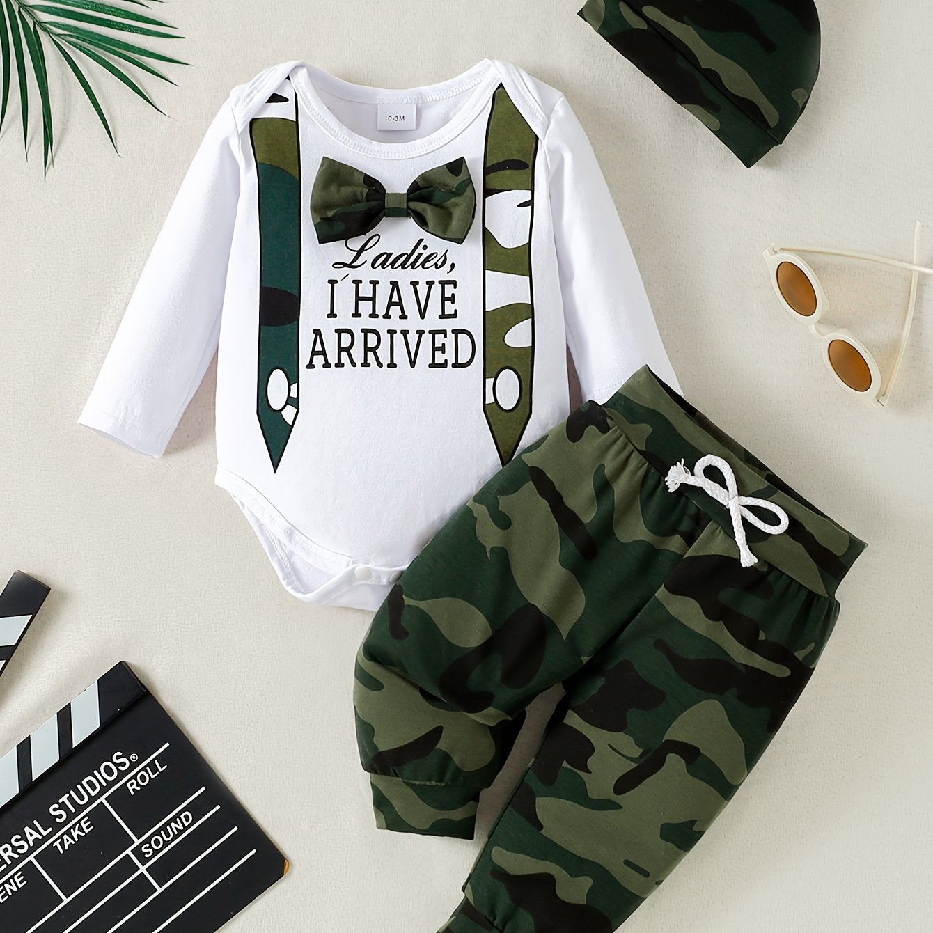 Three-piece set for stylish boys and babies includes a camouflage bow long-sleeved shirt, pants, and hat.