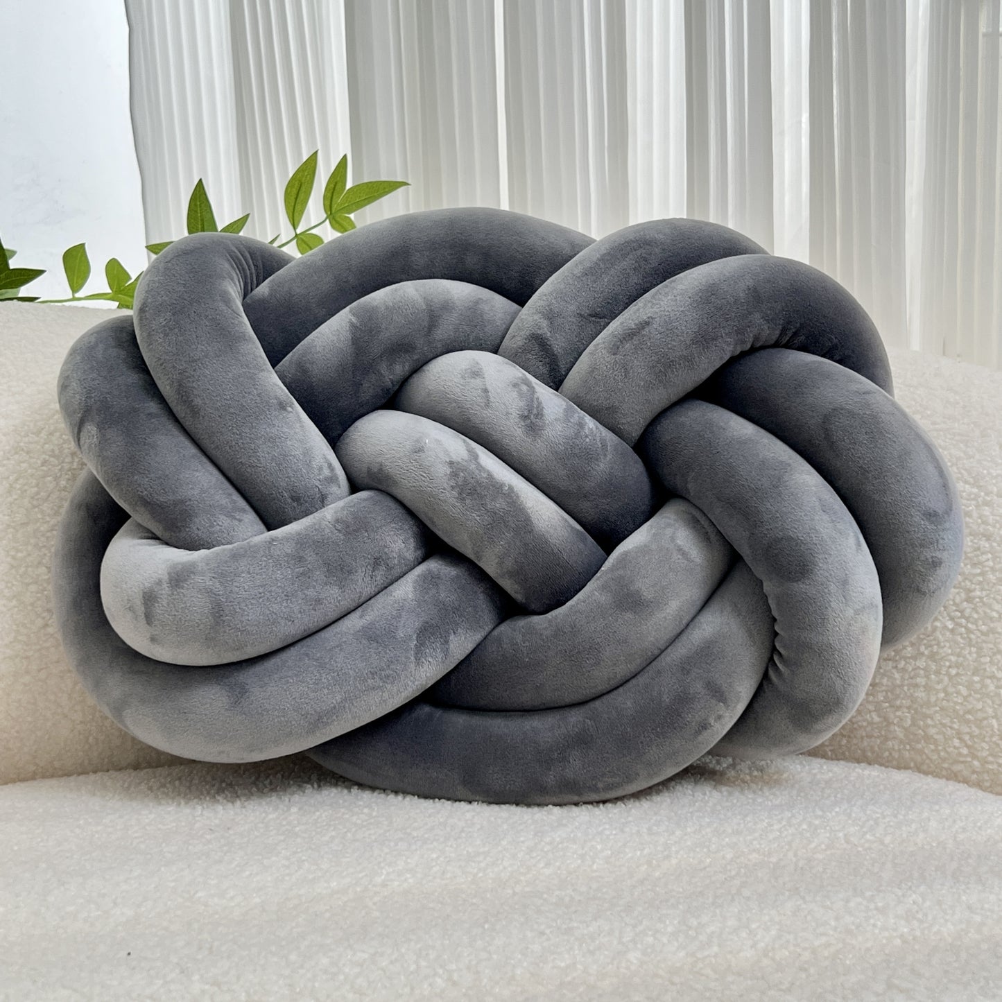 Knotted throw pillow for home decor, suitable for bed or sofa.