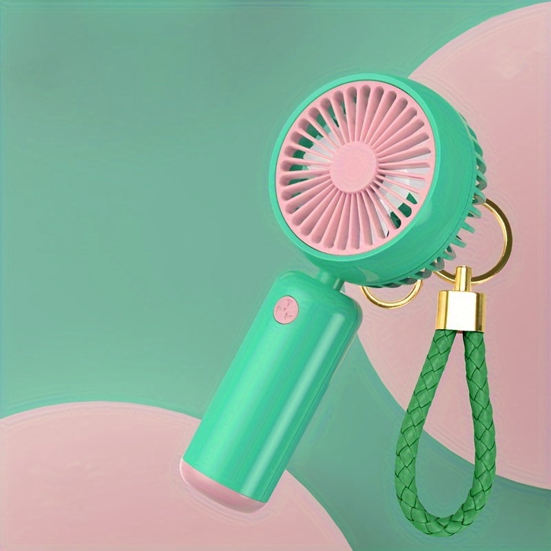 Small handheld portable fan with USB rechargeable battery, three adjustable speeds, and wearable design for use both indoors and outdoors.