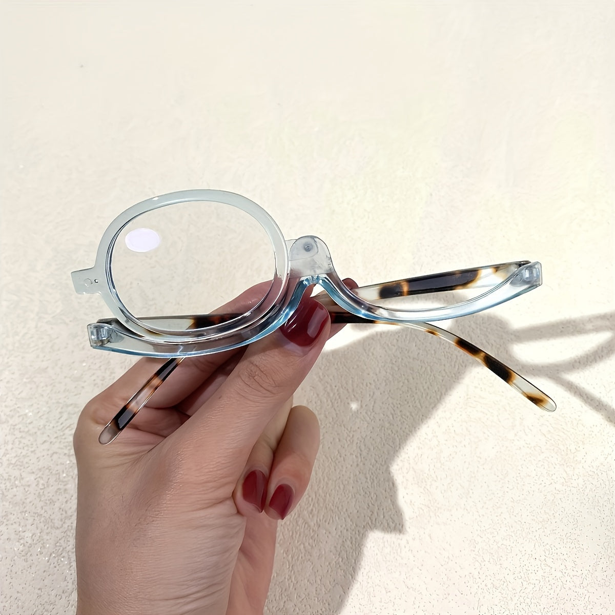 Rotating cosmetic reading glasses for makeup application, covering prescription range +1.0 to +4.0.