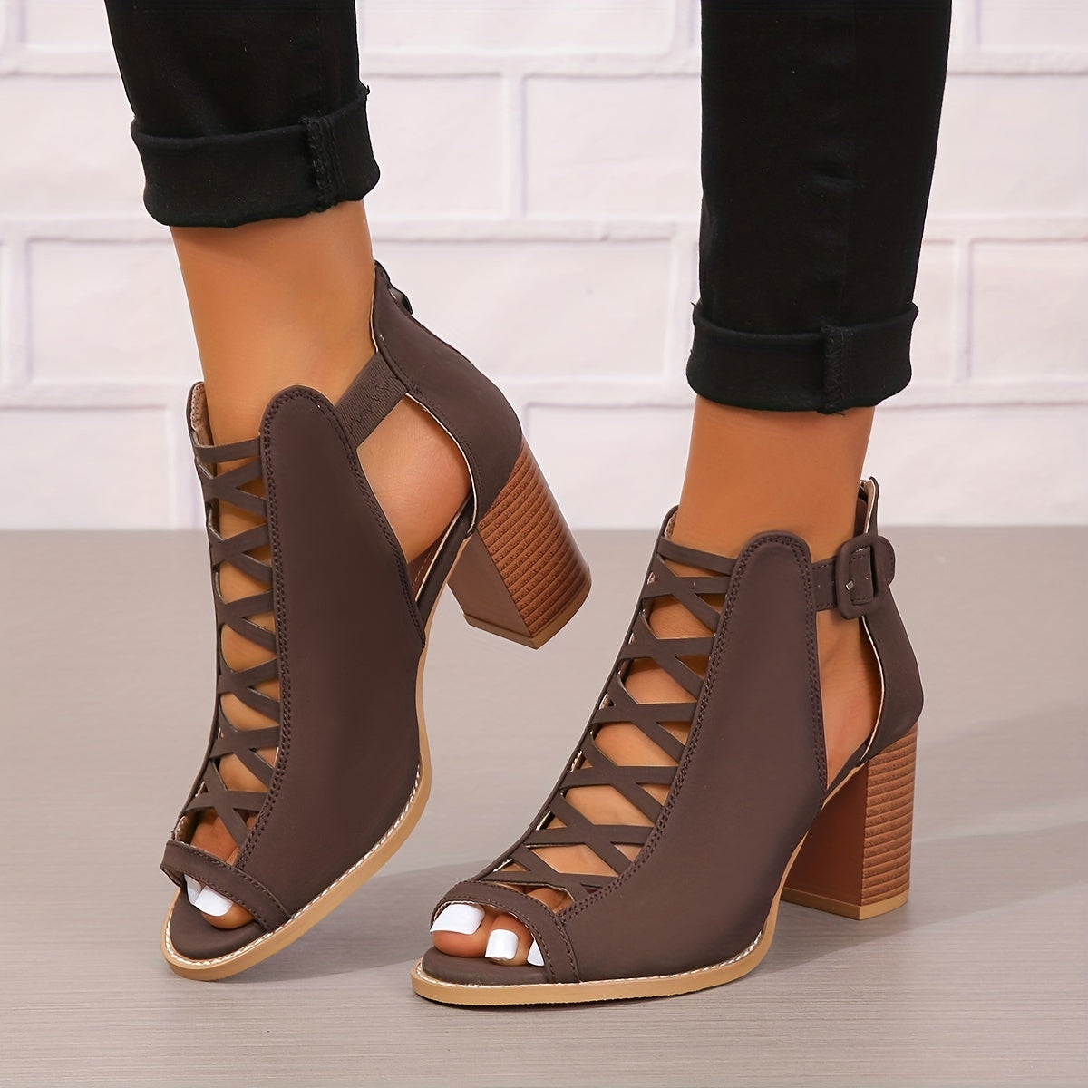 Women's brown faux leather ankle boots with elegant design including peep toe, chunky heel, crisscross straps, and buckle closure. Comfortable summer pumps with rubber sole.