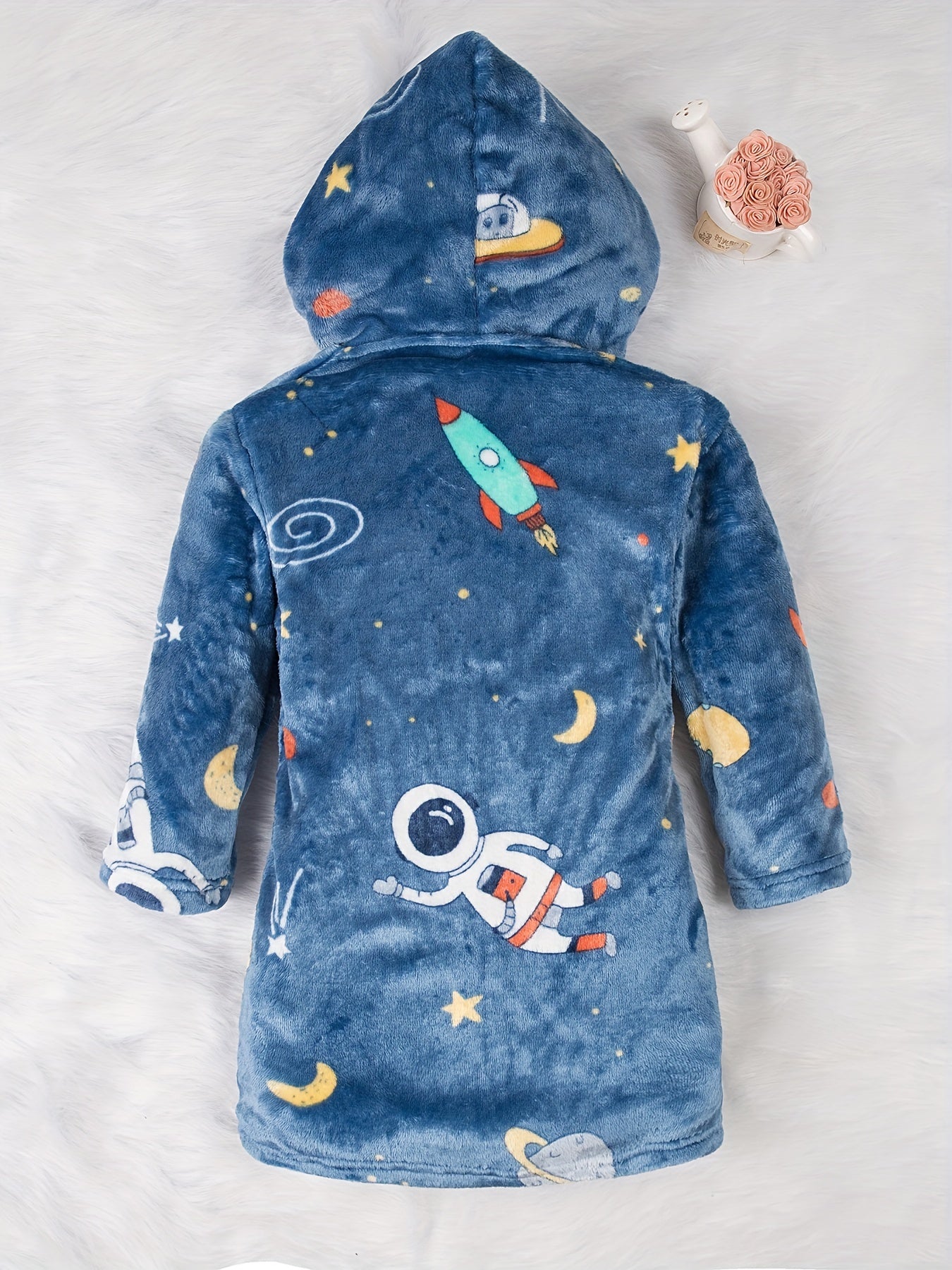 Soft and cozy space-themed boys' fleece robe with flame retardant technology. Features long sleeves, hood, pockets, and is machine washable. Ideal for home and party wear, perfect gift for