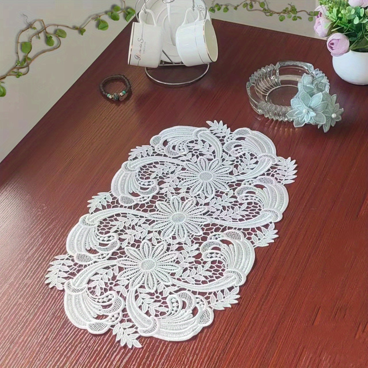 White velvet lace oval table runner with floral pattern, perfect for holiday table setting. Butterfly motif on decorative fabric for dining and home decor.