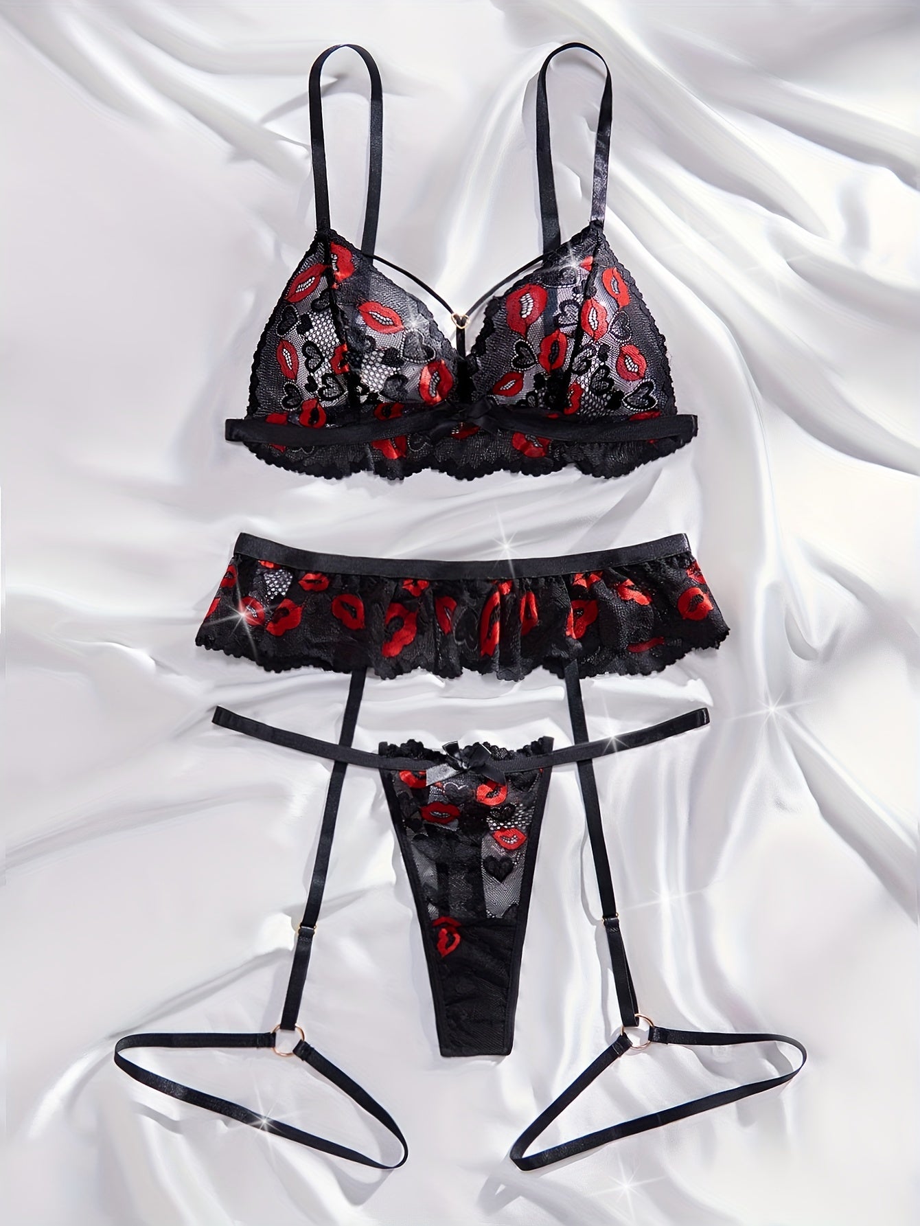 Lace lingerie set with red lips print and bow details. Includes transparent bra, G-string, and garter belt.