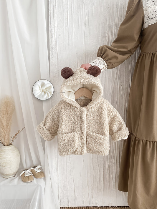 Warm and fuzzy hooded coat with cute bear ears for winter outdoor wear.