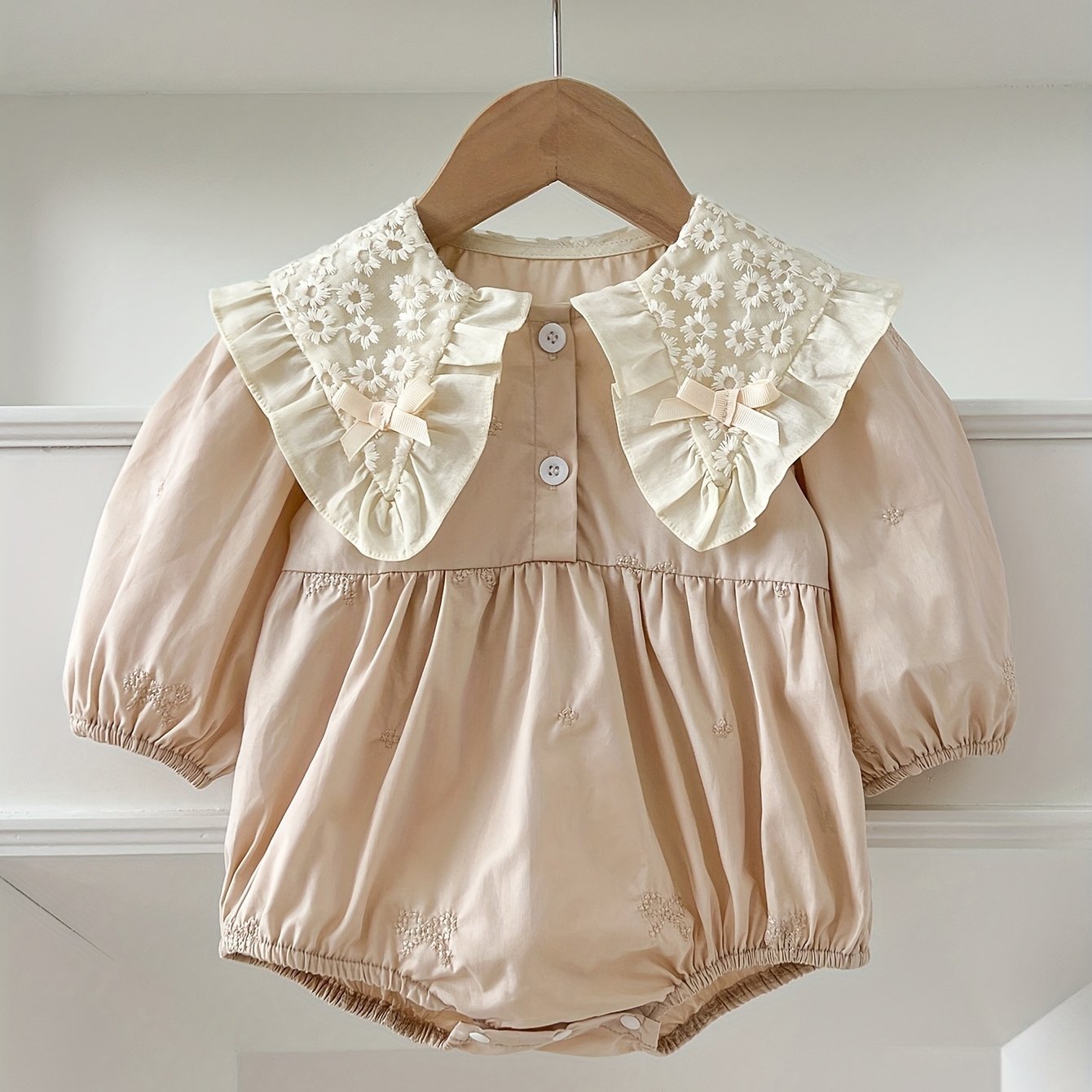 Stylish floral embroidered long-sleeve romper for baby girls, made of cotton with bow detail, ideal for spring/fall and outdoor wear.