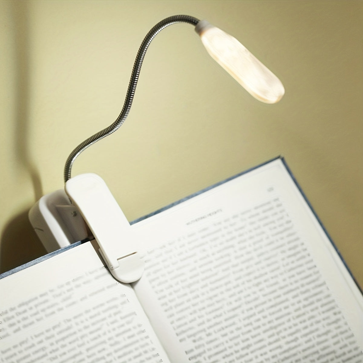 Portable battery-powered clip-on book light with a flexible hose, ideal for reading in small spaces or as a bedside night light.