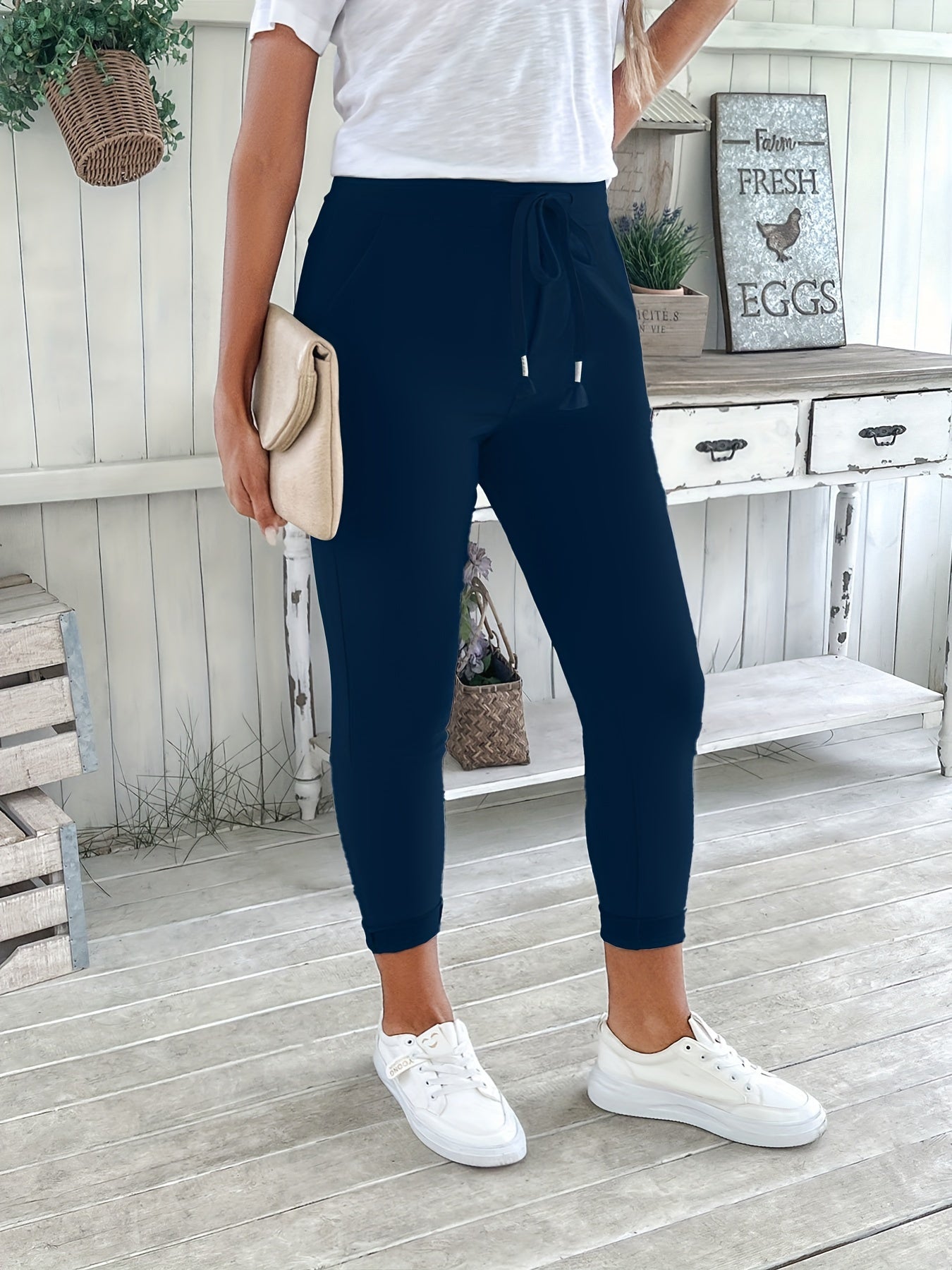 Navy blue drawstring jogger pants for women. Made of stretchy polyester with pockets. Machine washable. Comfortable and adjustable, perfect for all seasons.