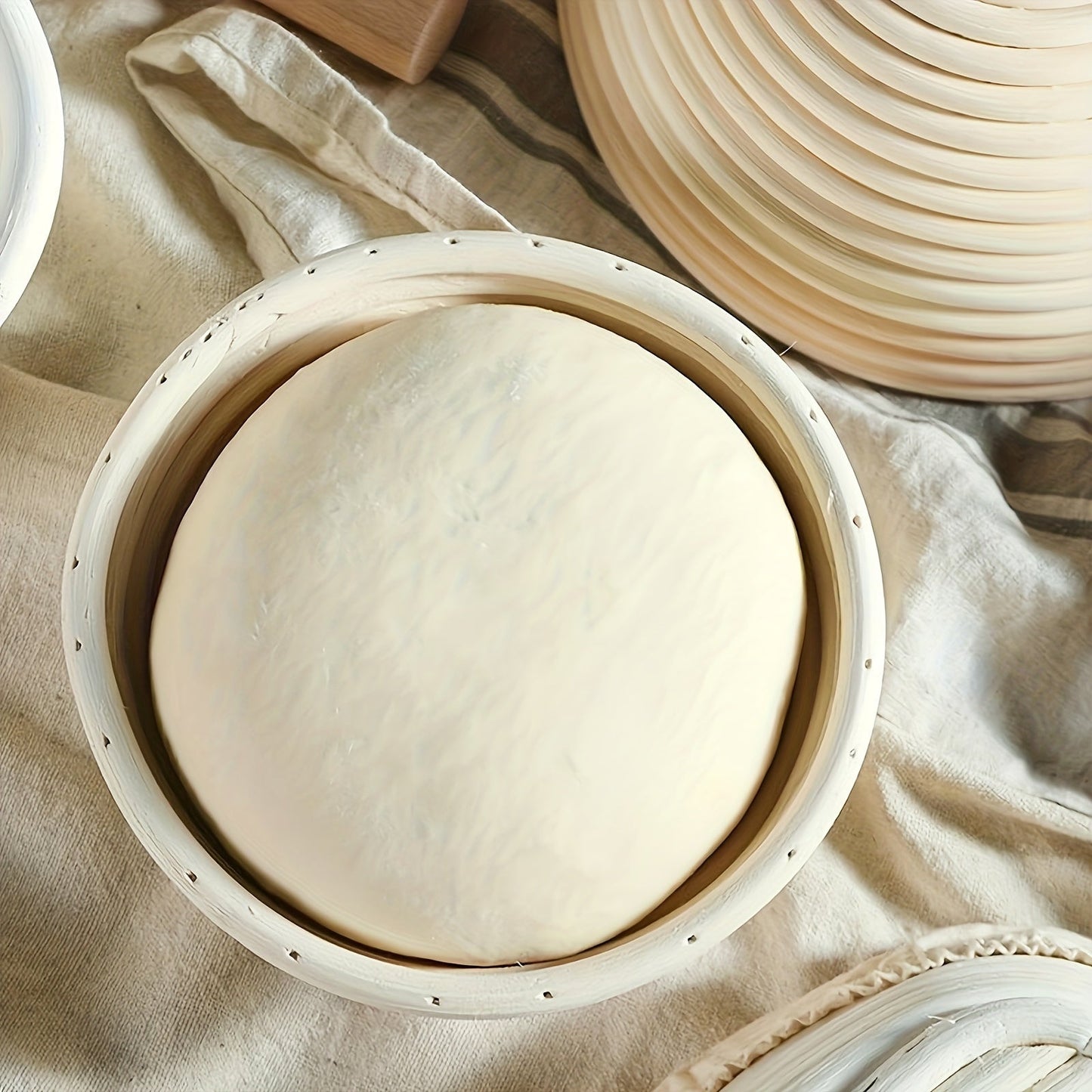 Set of two modern round bread proofing baskets with liners made from rattan. This banneton basket kit is ideal for baking artisan sourdough bread, providing a non-stick fermentation basket for home bakers and bread making.