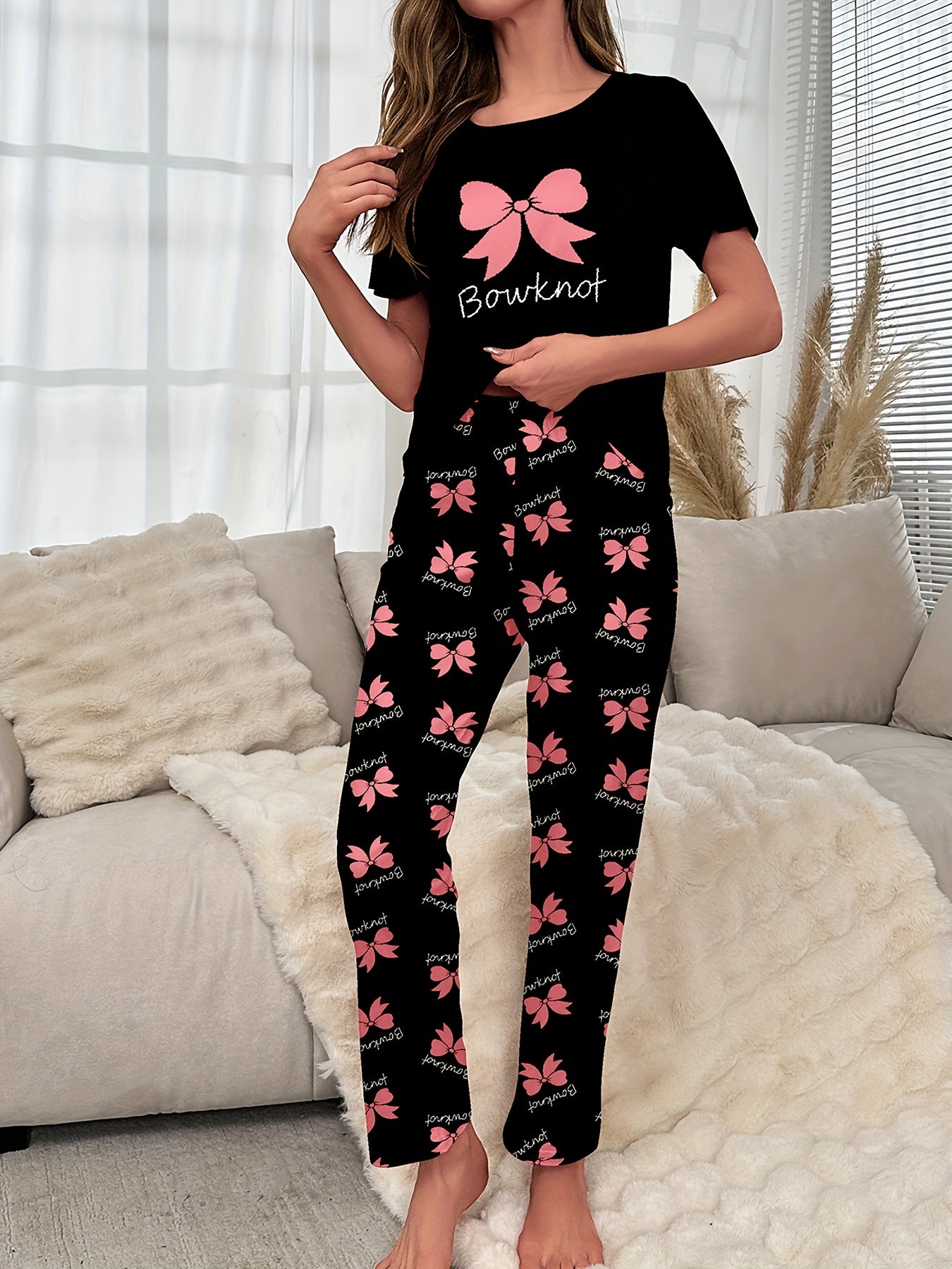 Women's sleepwear set with bow & slogan print, short sleeve top, and elastic pants.