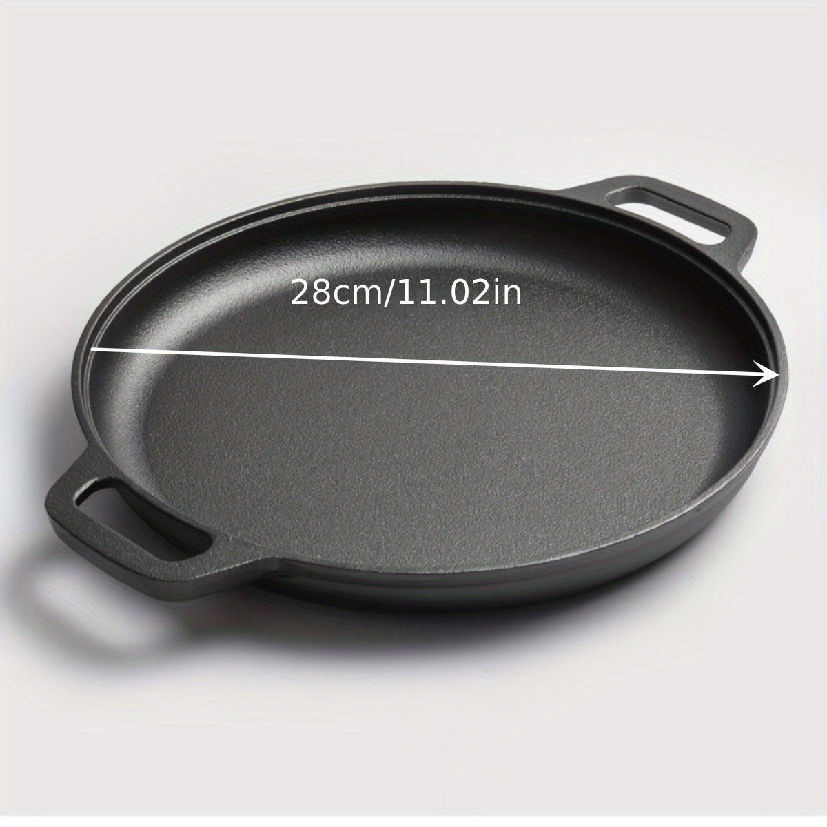 Double-handled non-stick frying pan for pancakes made of cast iron, meant for hand washing, with a durable uncoated surface ideal for cooking crepes and flatbreads.